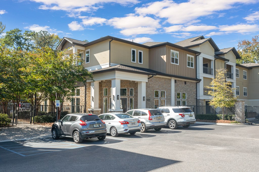 A row of cars are parked in front of a building.